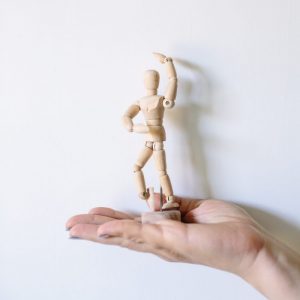 picture of a hand holding a model showing joints that are sore or inflamed due to osteoarthritis